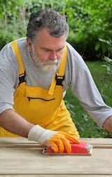 Badger Remodel carefully sanding and preparing a door for repairs and painting